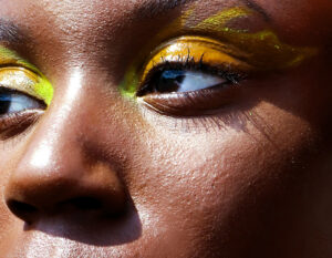 Close up on woman's eyes with fluorescent yellow graphic eyeliner