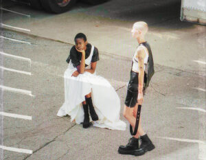 A photograph of two models in a parking lot wearing garments from pilotszn’s debut collection.