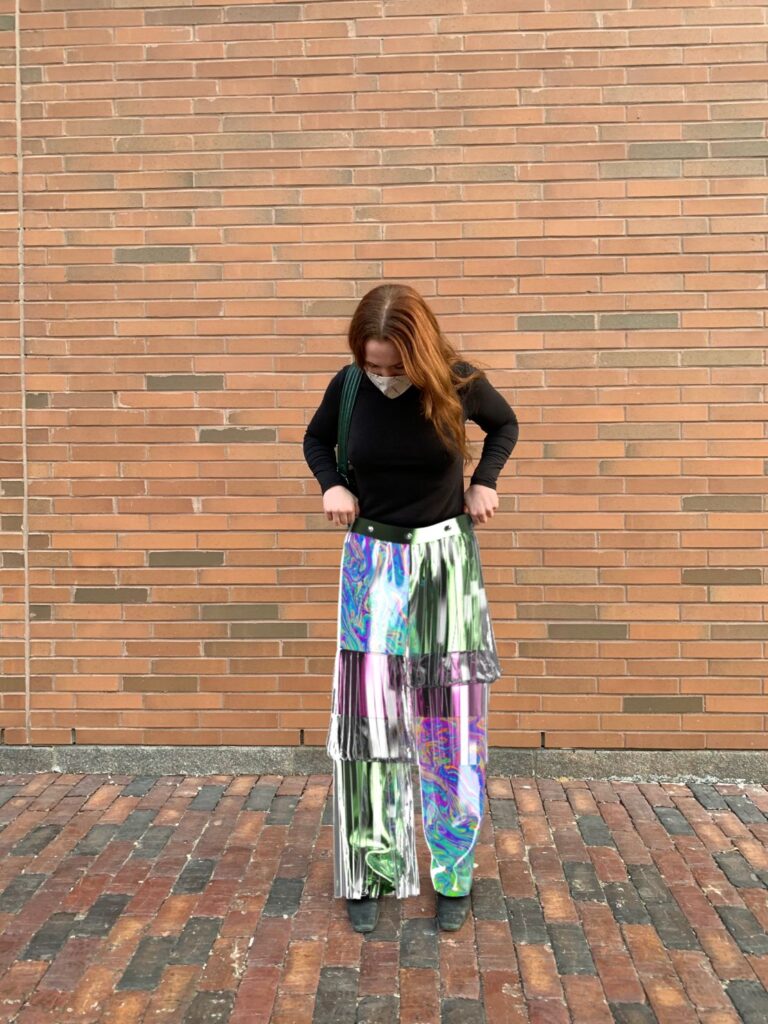 Jessi standing outside wearing digital holographic pants.