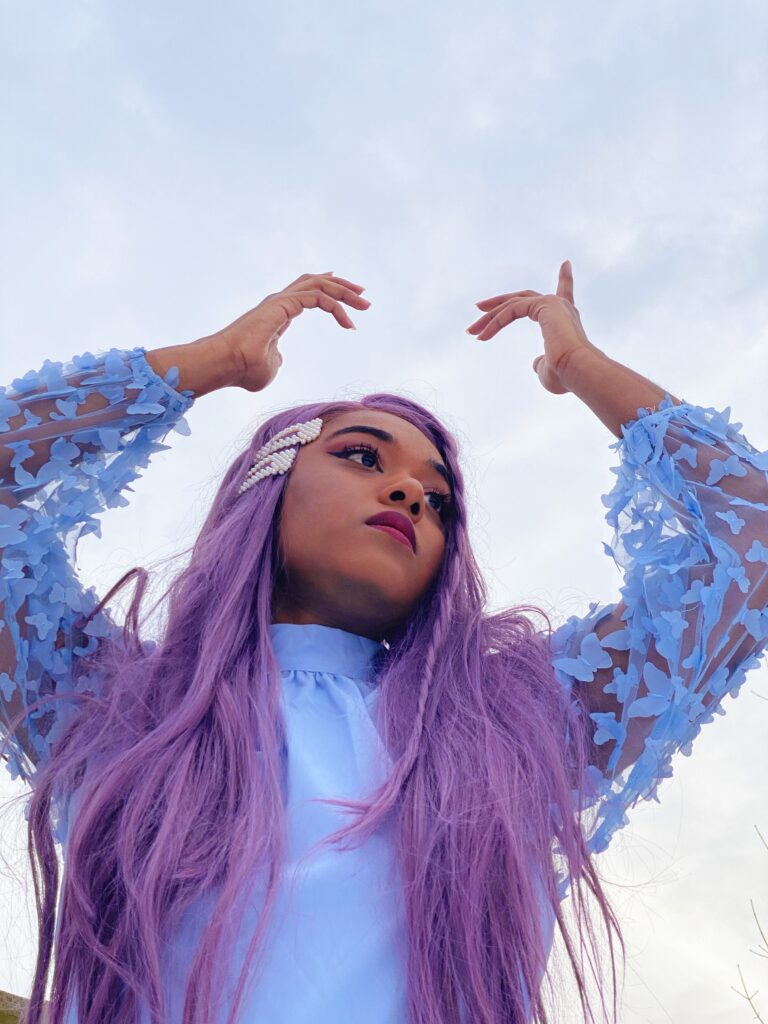 Maya is wearing a blue blouse from SHEIN, hair clips from wowyesh, mom jeans from H&M and purple wig from FOXWIGS.