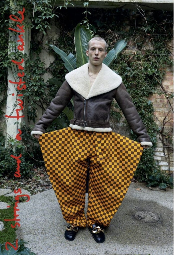 JW Anderson F/W 2021 collection, man in yellow and brown checked pants and sherpa fleece jacket.